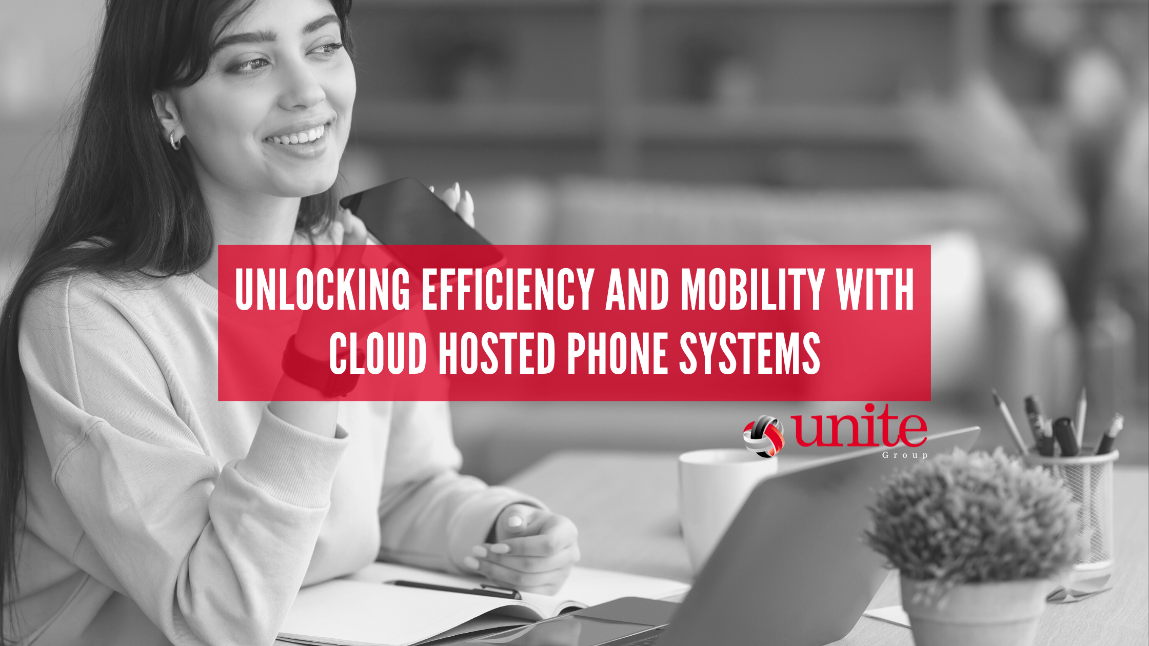 lady on mobile phone with laptop on the desk. unlcoking efficiency and mobility with cloud hosted phone systems